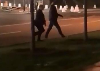 Some other men saunter up to the pair at the end of the video
